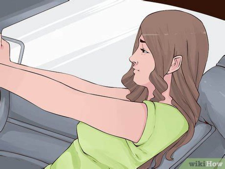 Where should you sit to avoid car sickness?